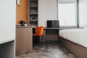 a bedroom with a bed and a desk with a chair at Quarter by the Warren Collection in Belfast