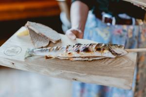 a piece of fish on a wooden cutting board at Das Franzl - Bett & Brot in St. Wolfgang