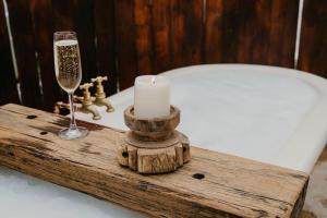 een houten dienblad met een kaars en een glas champagne bij Olive Grove Winton in Winton