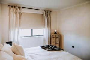 a bedroom with a white bed and a window at Olive Grove Winton in Winton