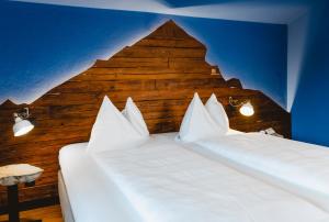 two beds in a room with a wooden wall at Das Franzl - Bett & Brot in St. Wolfgang