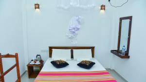 a bedroom with a bed with two pillows on it at Menara Green Inn in Dambulla