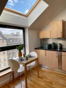 a kitchen with a table and chairs and a window at Edinburgh Penthouse 101 in Edinburgh