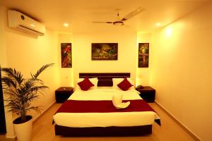 a bedroom with a large bed and a plant at ORFILA INN Airport Hotel in Angamali