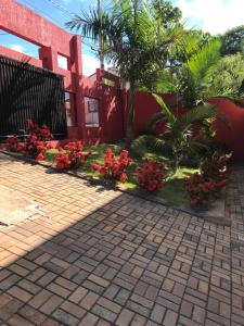 a house with red flowers and a brick driveway at Imperial Park in Cornélio Procópio