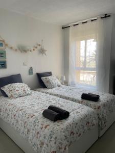 um quarto com 2 camas e toalhas em Las Palmeras em Algarrobo