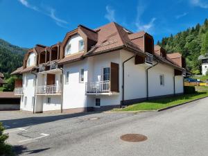 a white building with a brown roof on a street at S-apartment Wiedweg in Wiedweg