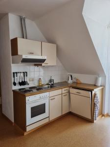 a small kitchen with a stove and a sink at S-apartment Wiedweg in Wiedweg