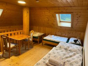 a room with two beds and a table in a cabin at S-apartment Wiedweg in Wiedweg