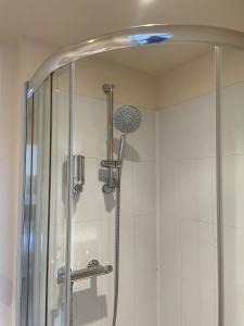 a shower with a glass door in a bathroom at Diamonds Lodge near York Hospital in York