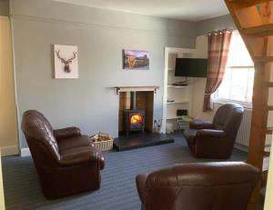 a living room with two chairs and a fireplace at Rowan Cottage Wanlockhead Dumfries & Galloway in Wanlockhead