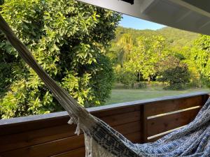 a hammock on a porch with a view of the forest at Les Lodges de Malendure in Bouillante