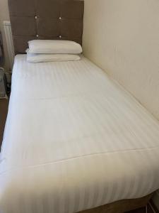 a large white bed in a small room at Diamonds Lodge near York Hospital in York