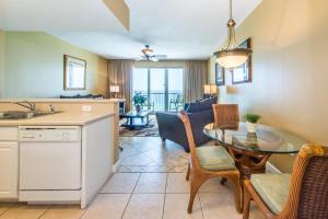 cocina y sala de estar con mesa y sillas en Seychelles 907, en Panama City Beach