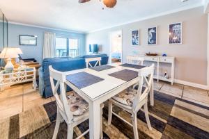 a dining room and living room with a table and chairs at Moonspinner 211B in Panama City Beach