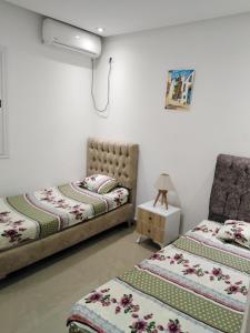 sypialnia z 2 łóżkami i krzesłem w obiekcie Pretty and independent Apartment located in Tunis city w mieście Tunis