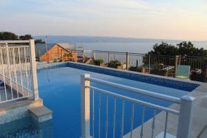 uma piscina numa varanda com vista para a água em Kuća za odmor R&A em Podstrana
