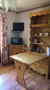 una gran mesa de madera en una habitación con TV en APPARTEMENT PRAZ VILLAGE en Praz-sur-Arly