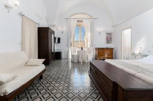 a bedroom with a bed and a table in it at Hotel La Terra in Ostuni