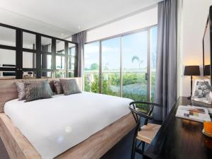 a bedroom with a bed and a large window at The 8 Pool Villa in Chalong
