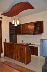 a kitchen with wooden cabinets and a blue refrigerator at Shreya Guest House in Ubud
