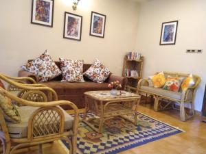 un soggiorno con divano e sedie di Haven Amidst Nature in Villa Palmas, Arpora a Goa Velha