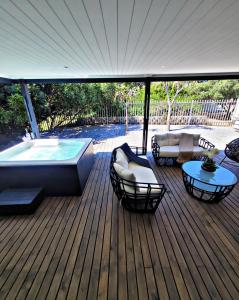 a deck with a hot tub and a table and chairs at Sea you on Sands in Wilderness
