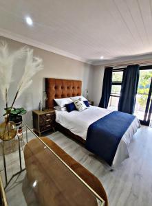 a bedroom with a large bed and a large window at Sea you on Sands in Wilderness