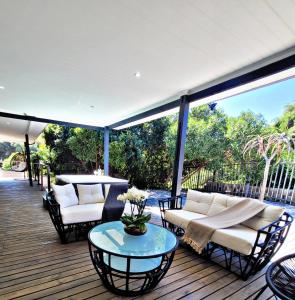 a deck with couches and chairs and a table at Sea you on Sands in Wilderness