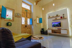 a living room with a couch and a tv at Ta' Ġilard - Lovely Renovated Holiday Home in Żabbar