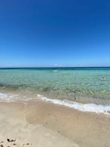 una spiaggia sabbiosa con l'oceano sullo sfondo di La Fenice sulla spiaggia a Gallipoli