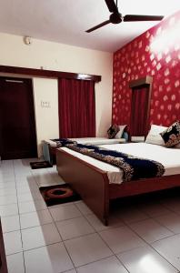 1 dormitorio con 2 camas y pared roja en Hotel Majors Den, en Nueva Delhi