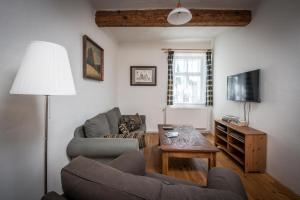 Una sala de estar con un sofá, una mesa y un televisor. en Roubená chalupa Český ráj Nadslav, en Střevač