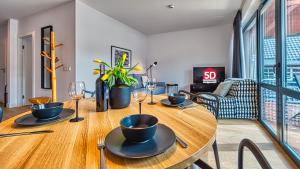 ein Esszimmer mit einem Holztisch mit Weingläsern in der Unterkunft Apartament Triventi 98 z Widokiem- 5D Apartamenty in Karpacz