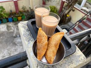 a bowl of food and two drinks on a table at Katyuri Kings Divine Stay- Babaji's cave in Dwārāhāt