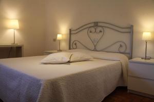 a bedroom with a white bed with a heart headboard at Tenuta Domine in Imperia +60 photos