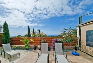 a patio with chairs and a table and a fence at Shanti Paphos Villa in Paphos City
