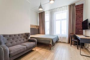 een woonkamer met een bank, een bed en een bureau bij Stylish City Center Studio Apartment in Tallinn