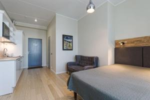 een slaapkamer met een bed en een bank en een keuken bij City Center Studio Apartment in Tallinn