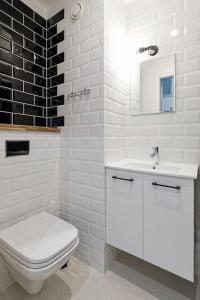 een witte badkamer met een toilet en een wastafel bij Stylish City Center Studio Apartment in Tallinn