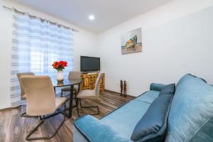ein Wohnzimmer mit einem blauen Sofa und einem Tisch in der Unterkunft Apartment Mia in Dubrovnik