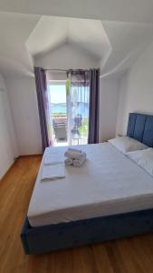a large bed in a room with a large window at Apartmani Ferdi in Trogir