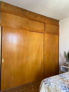a large wooden closet in a bedroom with a bed at Casa Yolcatl in Mexico City