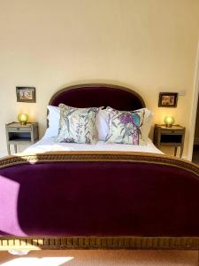 - une chambre avec un grand lit et une tête de lit violette dans l'établissement 50a Low Petergate, à York