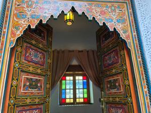 Habitación con cortina y ventana en Riad Le Petit Patrimoine De Fés en Fez