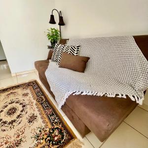 1 dormitorio con cama con almohadas y alfombra en Nossa Casa, Sua Casa 02 - Excelente Localizacao, en Paraty