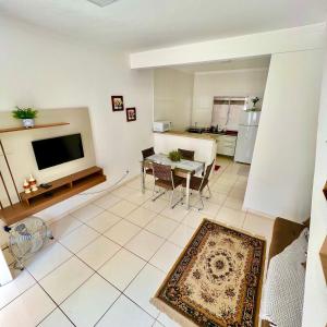 a living room with a television and a table with chairs at Nossa Casa, Sua Casa 02 - Excelente Localizacao in Paraty