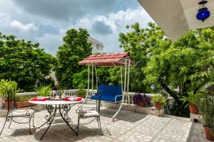 a patio with a table and chairs and an umbrella at Pratap Bhawan Homestay in Jaipur