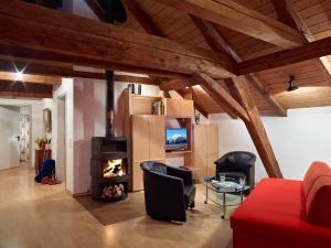 a living room with a fireplace and a red couch at Ferienwohnungen Hotel Eden Spiez in Spiez