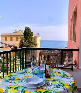a table with a bottle of wine and glasses on a balcony at "Home away from home" in Monterosso al Mare